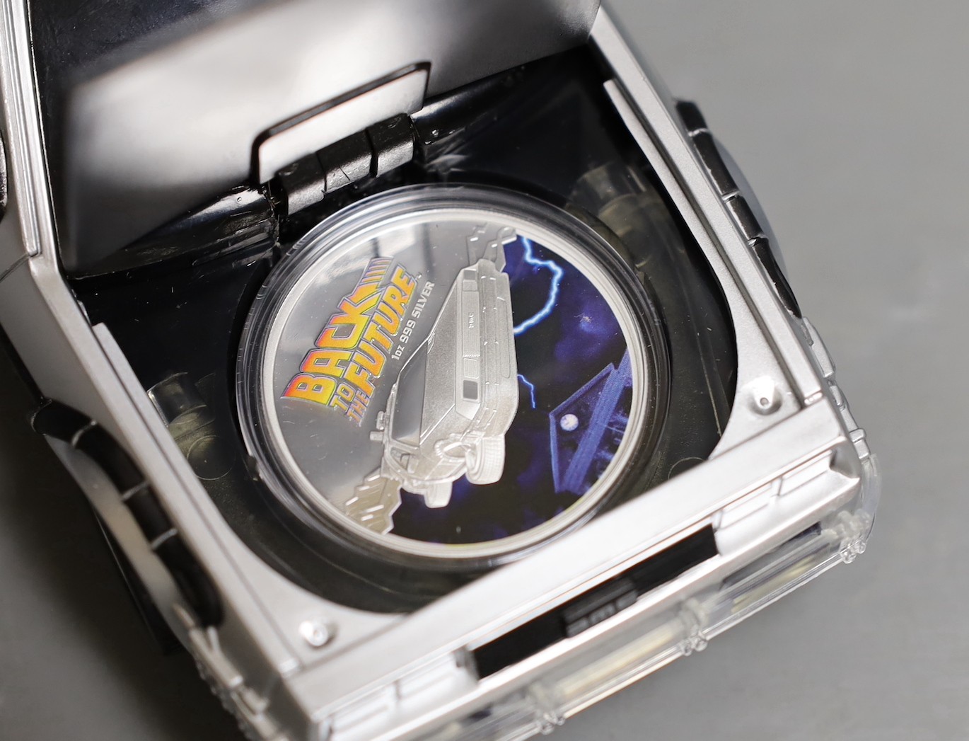 A Back to the Future DeLorean silver coin and model car set and an Australia mint 10oz bullion silver $10